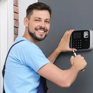 Ein Mann baut eine Alarmanlage in einem Haus ein