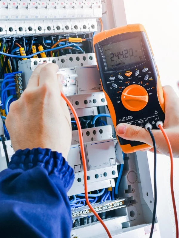 Ein Elektriker misst an einem Schaltkasten