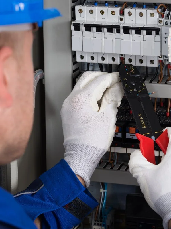 Ein Elektriker arbeitet an einem Schaltkasten
