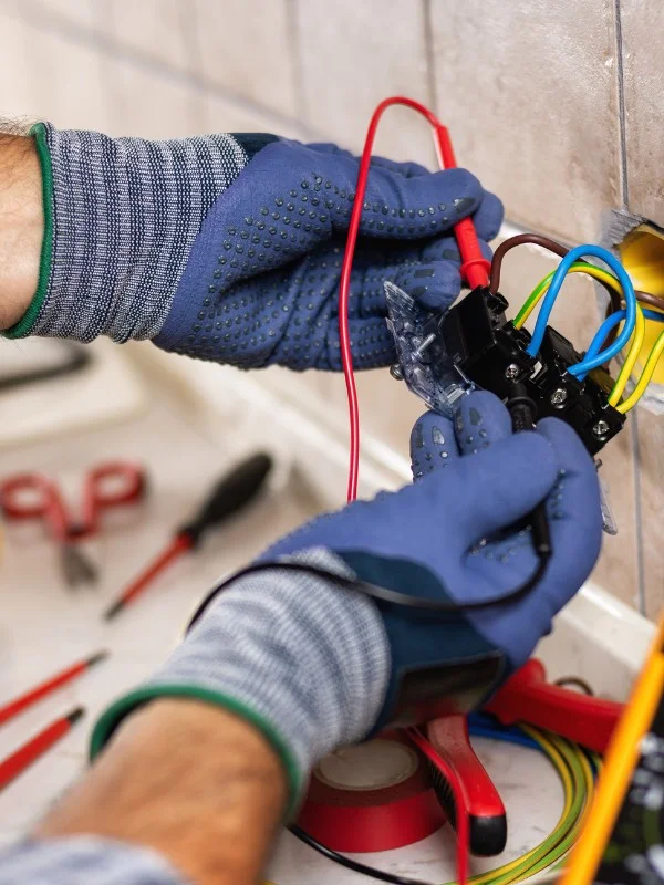 Ein Elektriker arbeitet an einer Steckdose