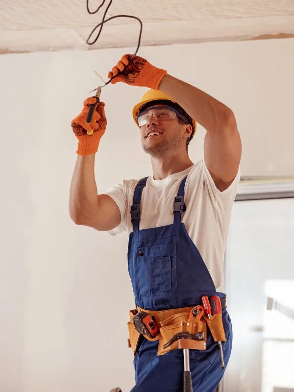 Ein Elektriker arbeitet an einer Deckeninstallation